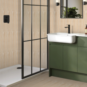 Bagno moderno con pavimento e rivestimento Natural Acacia effetto legno acacia chiaro, mobile sottolavabo verde salvia, box doccia con profili neri, lavabo sospeso bianco e piante verdi decorative